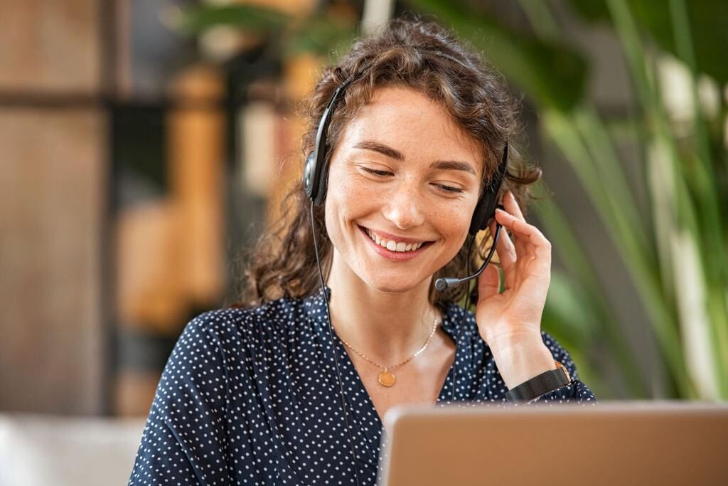 Freundliche Mitarbeiterin mit Headset am Telefon